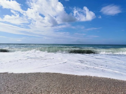 Roaring ocean waves on the beach under a clear blue sky, Dhermi, Albanian Riviera, Albania