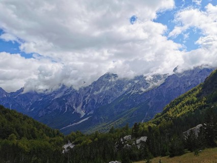 Mountain landscape with thick clouds and extensive forests in daylight, Peaks of the Balkans,