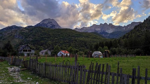 Idyllic farm against a dramatic mountain backdrop in the warm light of sunset, Peaks of the