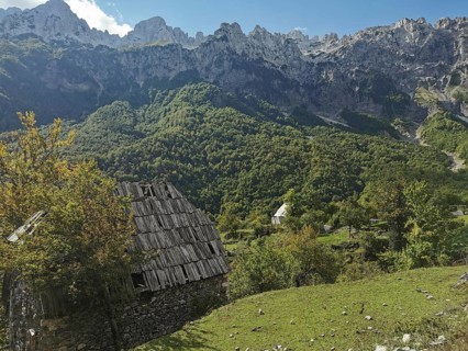 Dilapidated wooden house in a green mountain landscape under a blue sky, Peaks of the Balkans,
