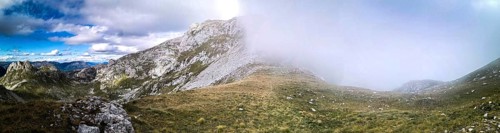 Panorama of a mountain landscape with fog moving over the hills and contrasting the sky, Peaks of