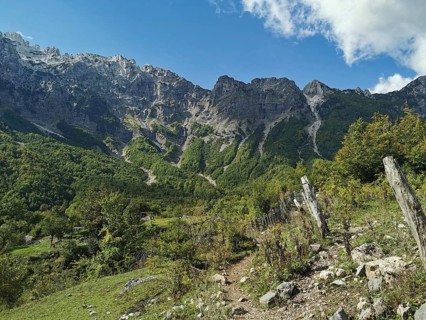 Mountainous area with fences and a hiking trail under a clear sky, Peaks of the Balkans, hiking in