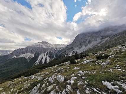 View of a mountainous landscape with dramatic clouds and rocks in the foreground, Peaks of the