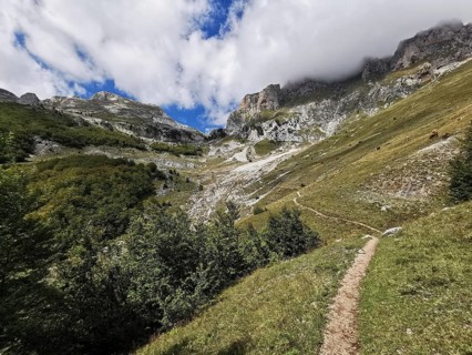 Trail through a mountainous landscape with dramatic clouds in the sky, Peaks of the Balkans, hiking