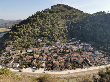 Panoramic view of a city on a hill surrounded by river and lush nature, Berat, Albania