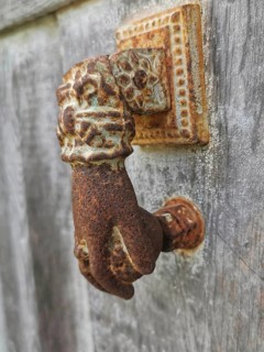 Close-up of a rusty antique door knocker in the shape of a hand, Berat, Albania