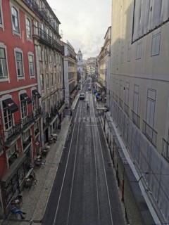 View from above of a long, empty city street with tram tracks, Lisbon, Portugal