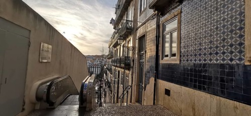 Evening atmosphere on a staircase with a view of decorated house facades and tiles, Lisbon,