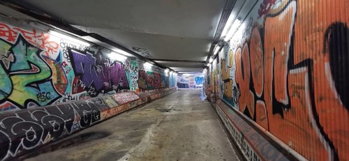 Long tunnel with colorful graffiti on the walls, urban flair, metro, Lisbon, Portugal