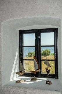 Window with sailboat decorations facing the sea in Smygehamn, Sweden's southernmost point in