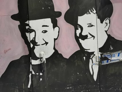 Black and white wall painting, graffiti, two smiling comedians, fat and stupid, Tirana, Albania
