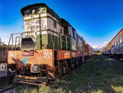 Colorful locomotive with graffiti in the sun on abandoned tracks, Albania
