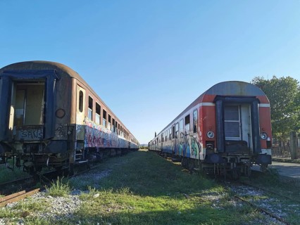 Two abandoned trains on parallel tracks covered by graffiti, former Deutsche Bahn, Albania