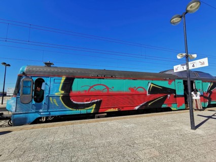 A train painted with graffiti stands on a sunny platform, Lagos, Algarve, Portugal