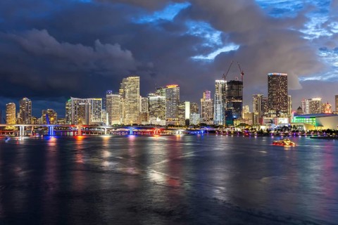 Miami skyline with high-rise real estate in downtown by the ocean at night in Miami, USA