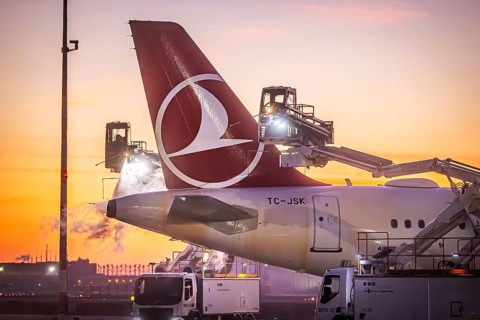 Frost at the airport in front of sunrise. A Turkish Airways aircraft is de-iced. Airbus A321-231.