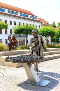 Silver figure explorer traveling by Ekaterina Kovalenko on Castle Square with bronze model of the