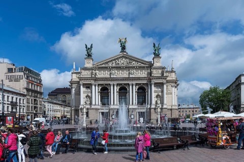 Hustle and bustle at the Opera Fountain, the Opera House in the back, Lviv, Ukraine