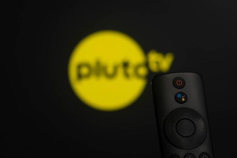 Dhaka, Bangladesh- 21 Jan 2026: Close-up of a smart TV remote control against a blurred pluto tv
