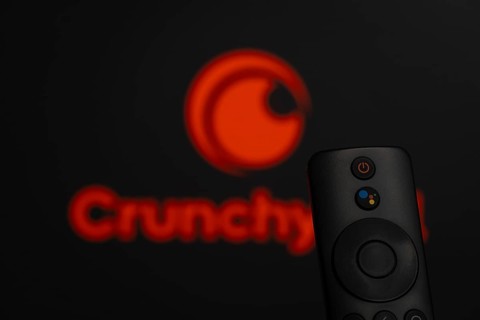 Dhaka, Bangladesh- 21 Jan 2026: Close-up of a smart TV remote control against a blurred Crunchyroll
