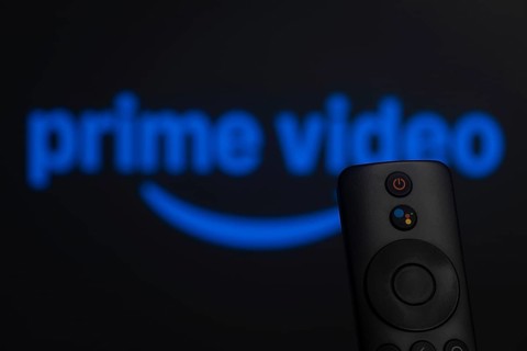 Dhaka, Bangladesh- 21 Jan 2026: Close-up of a smart TV remote control against a blurred Amazon