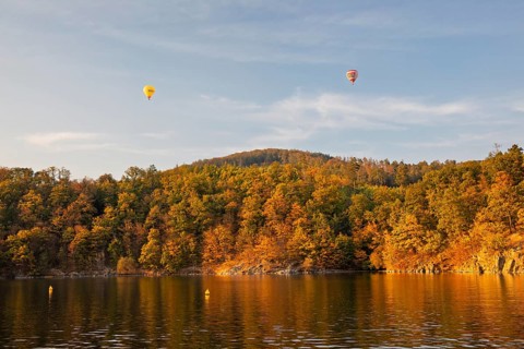 Hot air balloons over the Brno Reservoir (Brnenská prehrada) on the Svratka River on a sunny autumn