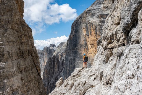 Hikers on the Sentiero Brentari via ferrata in front of cliffs, Brenta Mountains, Brenta-Adamello