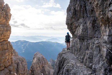 Climbers on a rock band, Bocchette Centrale band trail, via ferrata in the Brenta Mountains,