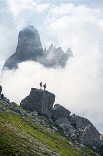 Alpine panorama, mountaineers on a large rock, fog and Torre Di Brentai and Cima Tosa, rocky