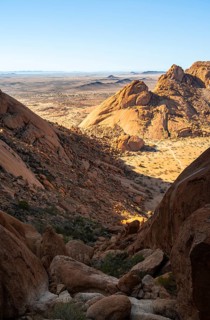 Rocks and low-lying desert plain in contrasting lighting, Spitzkoppe, Namibia