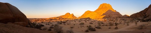 Mountains in the desert at sunset with bright shades of orange on the horizon, Spitzkoppe, Namibia