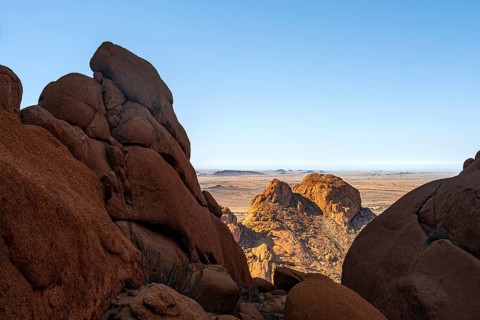Dramatic rock formations with views of vast desert landscape under clear skies in Spitzkoppe,