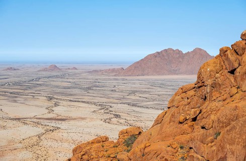 Red rocks with a wide desert view under a clear sky in Spitzkoppe, Spitzkoppe, Namibia