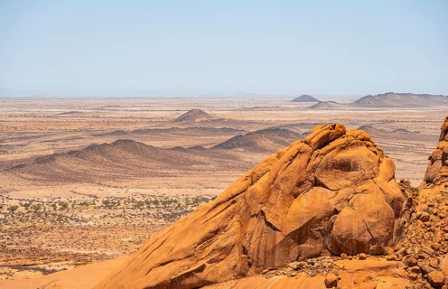 View of extensive desert landscape and distinctive rock formations on the horizon, Spitzkoppe,