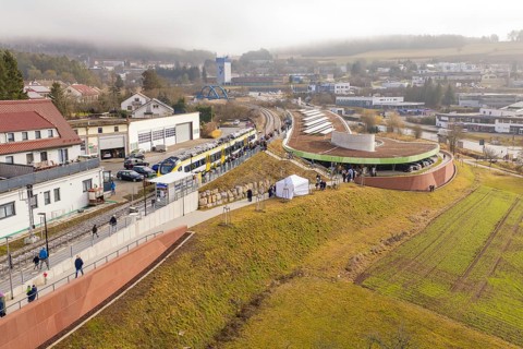 Panoramic view of a train with people in a hilly district during an event, opening of the Hermann