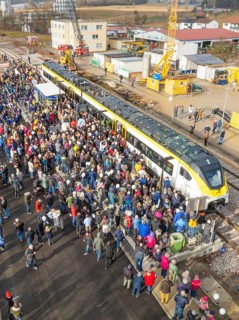 Assembly of people at a construction site event with a train, opening of the Hermann Hesse Railway,
