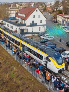 Train surrounded by a crowd in an urban area, aerial view, opening of the Hermann Hesse Railway,