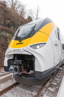 A modern yellow and white train front on the train tracks, opening of the Hermann Hesse Railway,