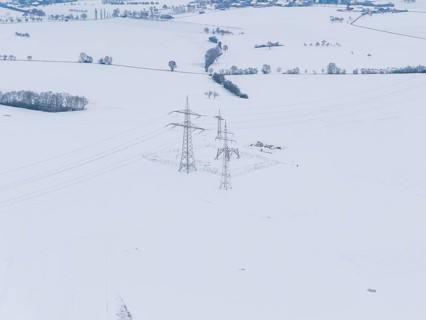 Snowy landscape with power lines running through a wide field, substation, Jettingen, Germany