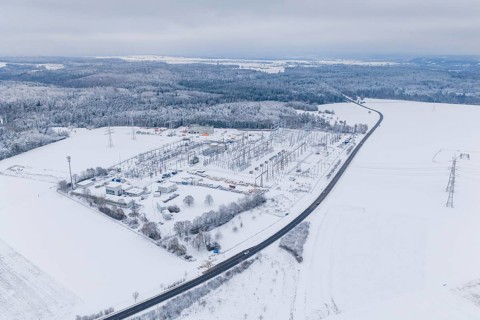 Snowy substation and road in the midst of a winter landscape with thick forests, substation,