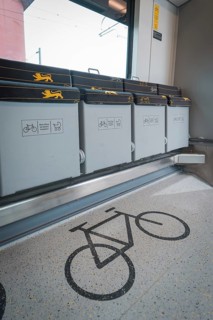Detailed view of a bicycle parking space in a train compartment with folding seats, battery