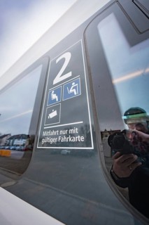 Window reflection with information on valid ticket and seats, battery electric train Siemens Micro