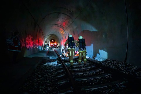 Firefighters walk through a tunnel in a dark, glowing atmosphere, fire drill at the Hermann-Hesse