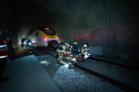 Firefighters during a rescue operation in a dark railway tunnel with a train, fire drill on the