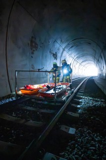 Firefighters stand on an ambulance in a tunnel, equipped for a mission, fire drill on the