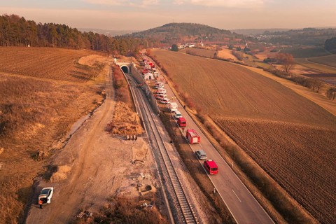 Aerial view with emergency vehicles next to a tunnel and fields in the background, fire drill at