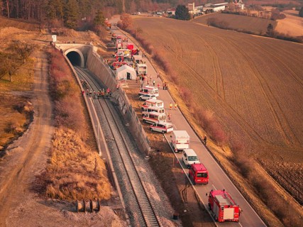 Aerial view of emergency vehicles along a tunnel next to a railway line, fire drill at the