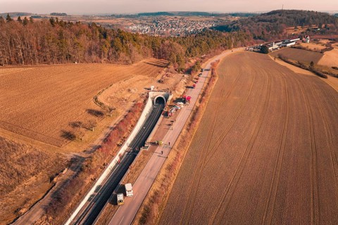 Tunnel with emergency vehicles and barriers along the road taken from the air, fire drill on the