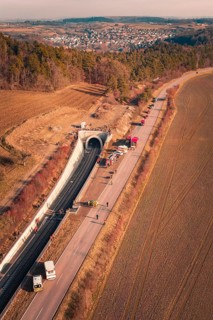 Aerial view of a tunnel with emergency vehicles and barriers along the road, fire drill on the