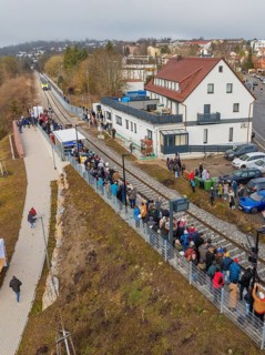 Numerous people lining up along the tracks in a village, opening of the Hermann Hesse Railway,